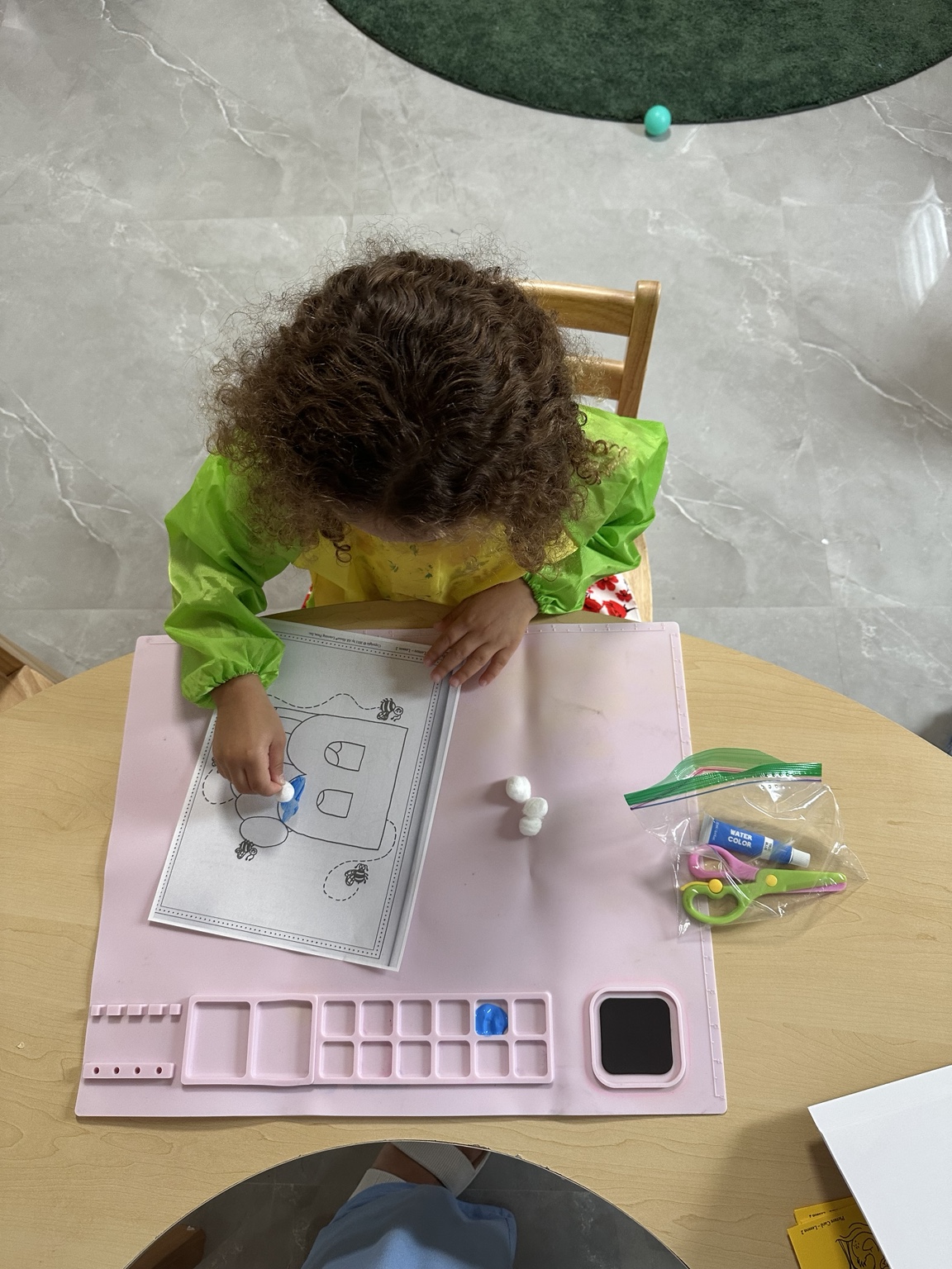 Child pointing to letter B on an alphabet chart