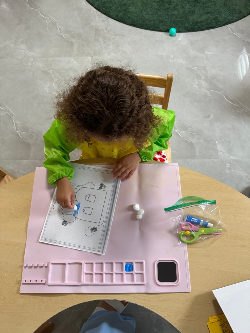 Child pointing to letter B on alphabet chart